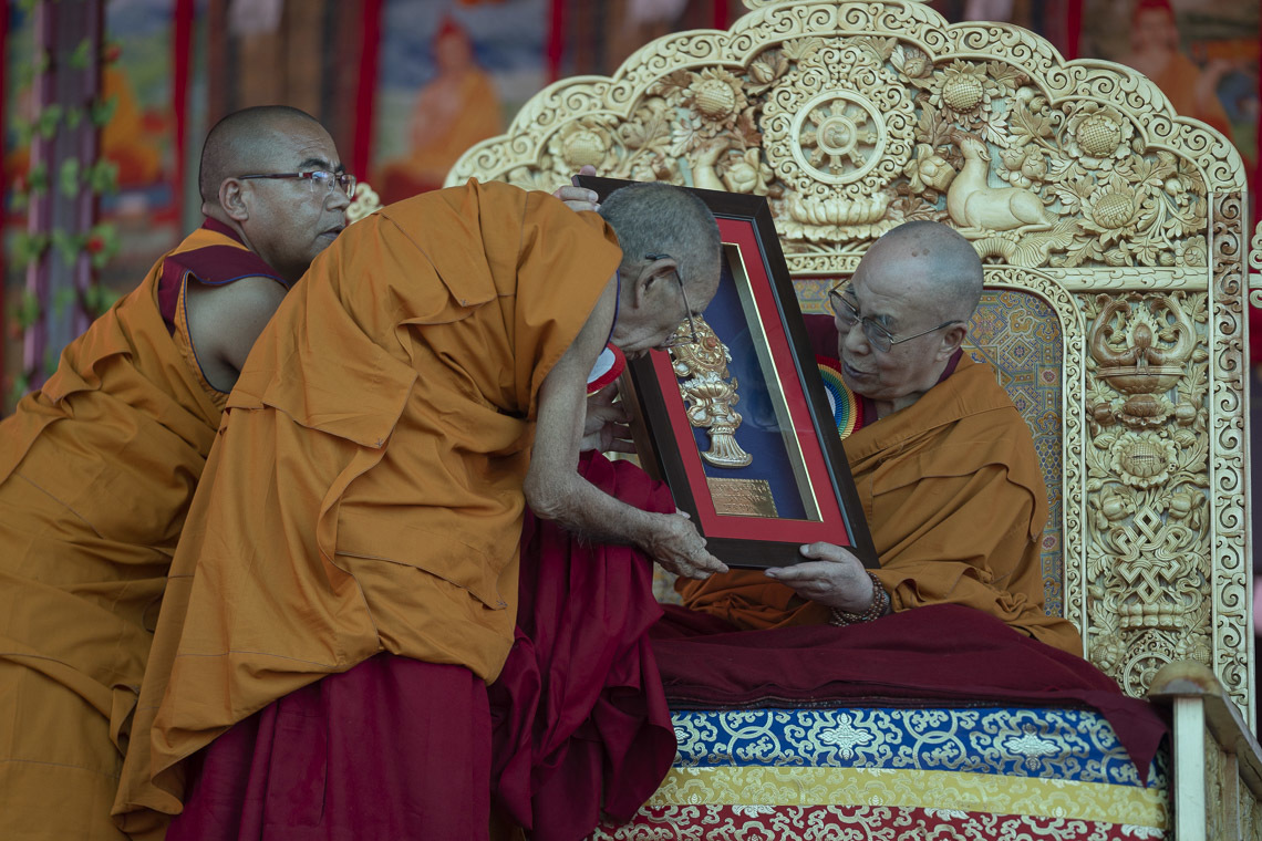 Ganden Trisour Rizong Rinpoché, présentant à Sa Sainteté le Dalaï-Lama un objet commémoratif de l'inauguration du grand débat d'été au monastère de Samstanling à Sumur, Ladakh, Inde, le 15 juillet 2018. Photo de Tenzin Choejor