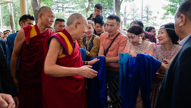 Sa Sainteté le Dalaï-Lama salue les membres du public dans la cour du temple principal tibétain alors qu'il se rend au dialogue entre universitaires russes et bouddhistes à Dharamsala, Inde, le 3 mai 2018. Photo de Tenzin Choejor