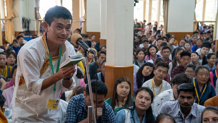 Un membre de l'auditoire pose une question à Sa Sainteté le Dalaï-Lama lors d'un entracte le premier jour des enseignements pour les jeunes étudiants tibétains au temple tibétain principal à Dharamsala,  Inde, le 6 juin 2018. Photo de Tenzin Phuntsok