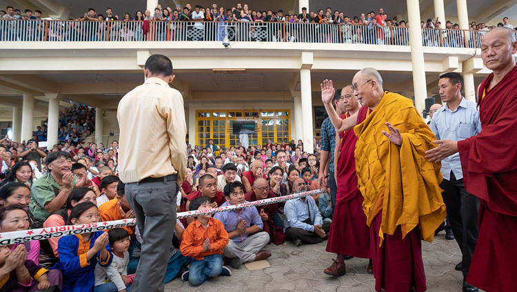 Sa Sainteté le Dalaï-Lama salue les membres du public assis dans la cour du temple principal tibétain alors qu'il retourne à sa résidence à la fin de ses enseignements pour les jeunes étudiants tibétains à Dharamsala, Inde, le 8 juin 2018. Photo de Tenzin Choejor