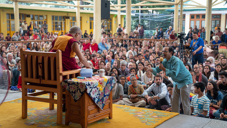 Un membre de l'auditoire pose une question à Sa Sainteté le Dalaï-Lama lors de sa rencontre avec des visiteurs indiens et étrangers dans la cour du temple principal tibétain à Dharamsala, Inde, le 9 juin 2018. Photo de Tenzin Choejor