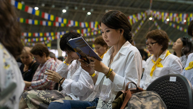 Les membres de l'auditoire lisent les textes avec Sa Sainteté le Dalaï-Lama le deuxième jour de ses trois jours d'enseignement à Riga, Lettonie, le 17 juin 2018. Photo de Tenzin Choejor