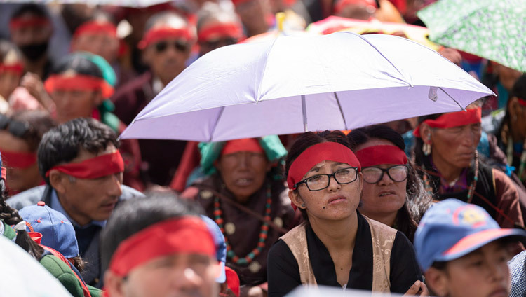 Quelques membres de l'auditoire utilisant des parapluies pour se protéger du soleil pendant l'initiation d'Avalokitéshvara conféréepar Sa Sainteté le Dalaï-Lama à Padum, Zanskar, Inde le 23 juillet 2018. Photo de Tenzin Choejor