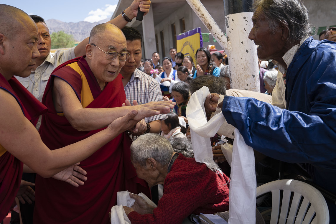 Sa Sainteté le Dalaï-Lama salue les Tibétains âgés alors qu'il arrive à l'école du village d'enfants tibétain de Choglamsar à Leh, Ladakh, Inde, le 1er août 2018. Photo de Tenzin Choejor