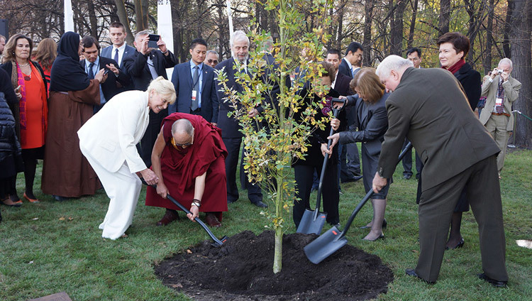 Betty Williams, Sa Sainteté le Dalaï-Lama, Shirin Ebadi, Mairead Maguire et Lech Walesa plantant un arbre à la fin du Treizième Sommet mondial des lauréats du Prix Nobel de la Paix à Varsovie en Pologne. Le 23 octobre 2013. (Photo de Jeremy Russel / OHHDL)